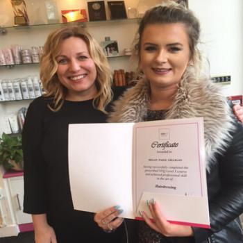Alan d apprentice Megan holding an Alan d hairdressing certificate.