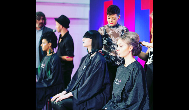 Three hair models having their hair cut.