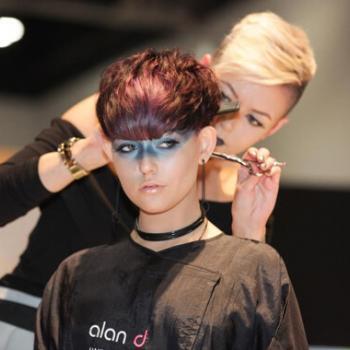 Alan d hairdressing student cutting a womans short auburn hair.