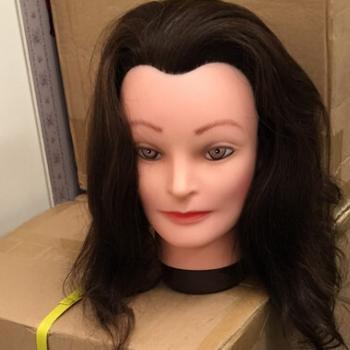 Hairdressing dummy head with dark brown hair.