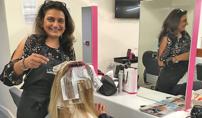 Alan d hairdressing teacher Sejal putting highlights in a womans hair.