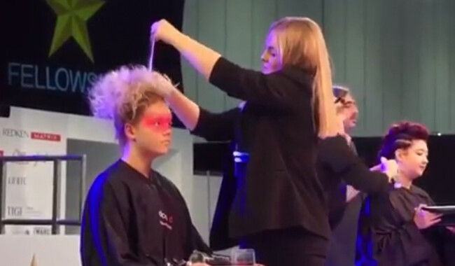 Alan d student styling a womans hair at the Salon International Exhibition.